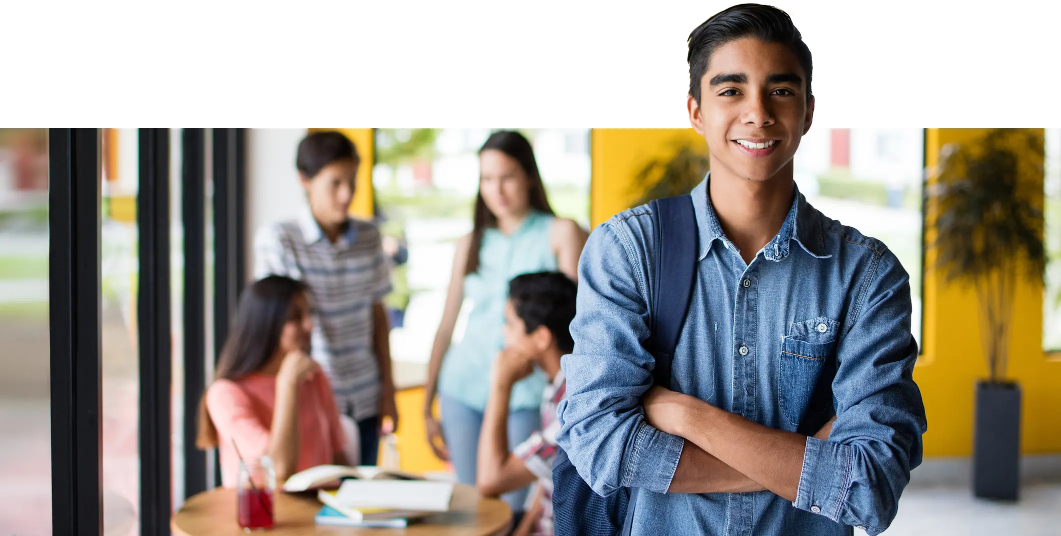 Student with backpack standing in classroom with peers