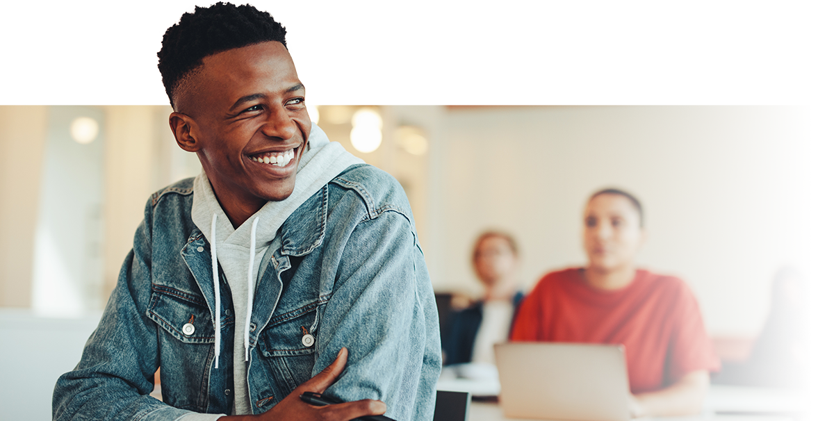 Student with backpack standing in classroom with peers