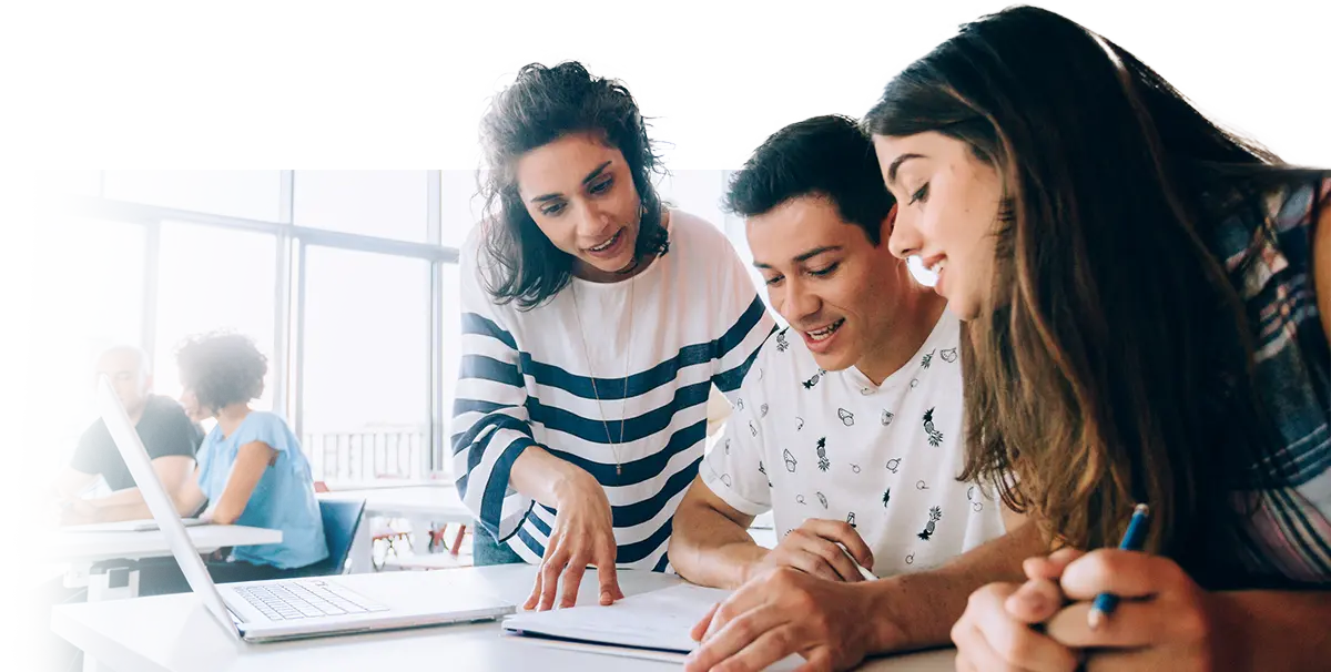 High school teacher reviewing paper with students